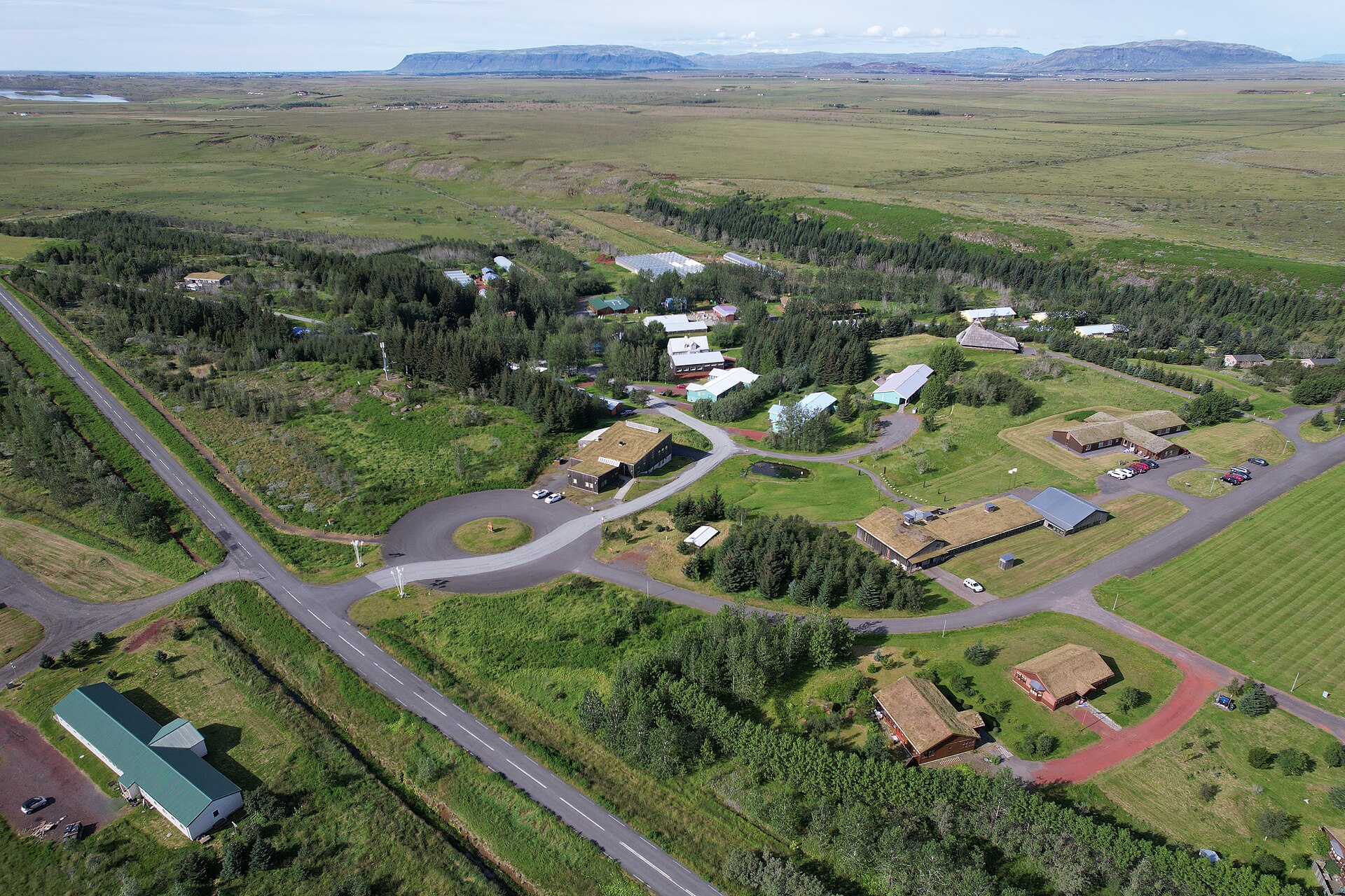 Aerial view of Sólheimar Eco Village in Iceland, with turf-roofed buildings among trees